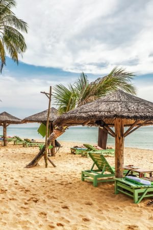 Wooden chairs and umbrellas on white sand beach at Phu Quoc island in Vietnam